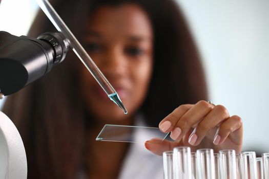A female chemist holds test tube of glass in his hand overflows liquid solution potassium permanganate conducts an analysis reaction takes various versions reagents using chemical manufacturing.