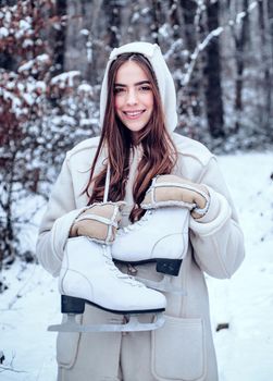 Winter woman. Outdoor portrait of young woman in cold sunny winter weather in park. Portrait of a beautiful woman dressed a coat