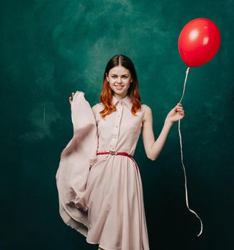 pretty woman in dress red balloon birthday green background. High quality photo