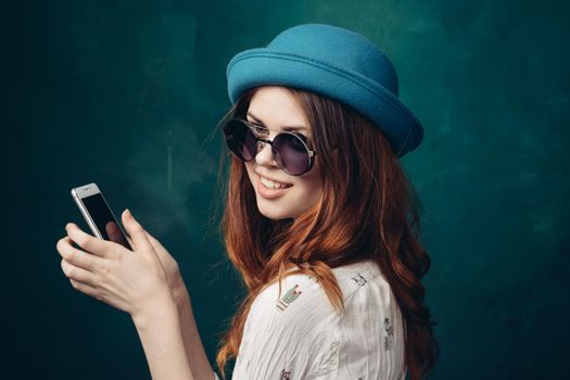 fashionable woman in blue hat with phone in hands communication technology. High quality photo