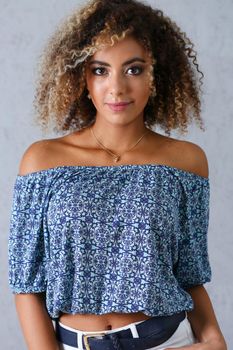 Beautiful black woman portrait. Worth a gray background and smiling beauty fashion style curly hair with white strands view of the eye in the camera