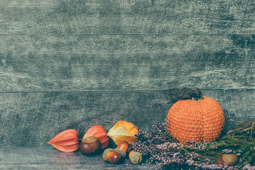 Autumn composition. Pumpkin, dried leaves and physalis on wooden background. Autumn, fall, halloween concept. Flat lay, top view, copy space