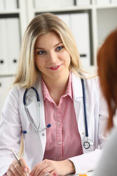 Beautiful smiling female doctor talk with patient about his history list. Physical exam er anamnesis communication disease prevention ward round 911 prescribe remedy healthy lifestyle concept