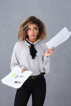Beautiful black woman portrait. Holds paper documents with financial statistics fashion style curly hair with white locks eye view of the camera lot of work