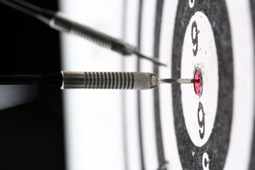 The dart game sticks out in the center of the red target an accurate hit to the target