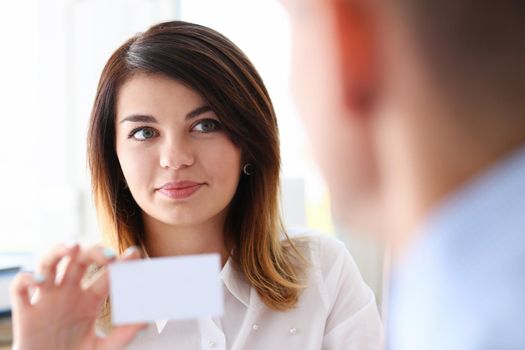 Female hand in suit give blank calling card to male visitor closeup. White collar partners company name exchange executive or ceo introducing at conference product consultant sale clerk concept