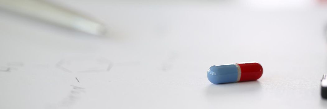 Tablets scattered blue and red color on the table of pharmaceutical laboratory pill for the prescription and treatment various diseases chemistry