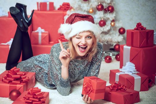 True Emotions. Young woman with Christmas present boxes in front of Christmas tree. New year eve girl. Beautiful Woman with Christmas box gif at Home