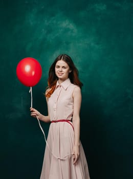 pretty woman in dress red balloon holiday green background. High quality photo