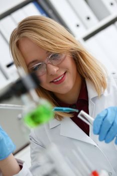 Technician hold in arms in protective gloves sample bottle with poison fluid portrait. Medical worker in uniform use reagent tube for virus infection exam or biological toxic reaction drug creation