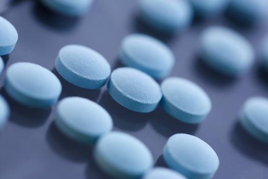 Tablets scattered blue color on the table of pharmaceutical laboratory pill for the prescription and treatment various diseases chemistry