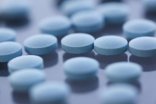 Tablets scattered blue color on the table of pharmaceutical laboratory pill for the prescription and treatment various diseases chemistry