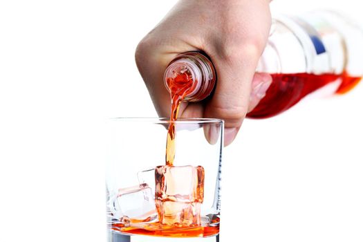 Male hand pours from bottle drink for a cocktail in glass beaker background