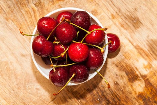 red ripens cherry, ripped from trees during harvest. Photo close-up. Berries lie in a porcelain dish