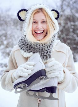 Winter woman. Wearing funny hat plaid scarf and coat. Winter holiday. Christmas. Beautiful woman walking in winter park and feeling wonderful