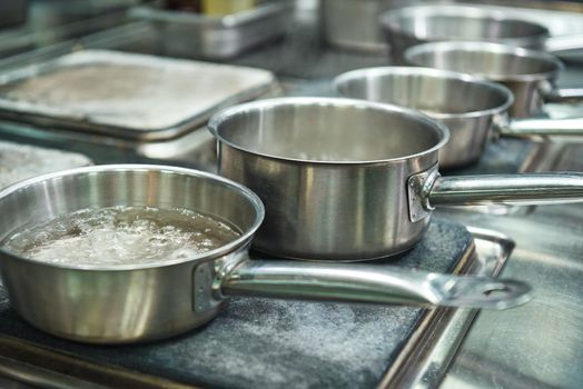 Next step. Close-up photo of boiling water in a metal pan for pasta cooking. Cooking equipment