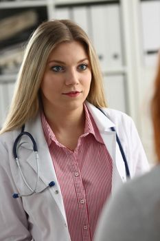 Smiling beautiful female medicine doctor explain diagnosis to male patient in business suit holding and showing pad. Physical disease prevention 911 prescribe remedy healthy lifestyle concept