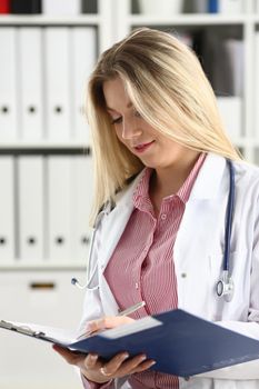 Female medicine doctor hand hold jar of pills and write prescription to patient at worktable. Panacea and life save, prescribing treatment, legal drug store concept. Empty form ready to be used