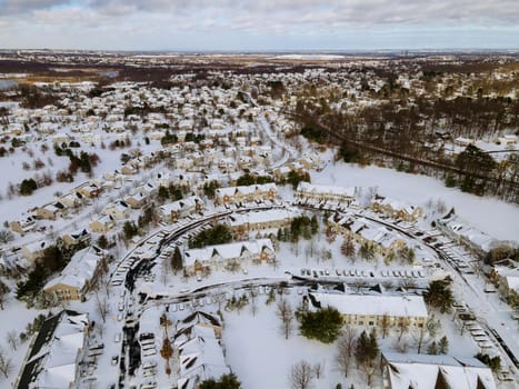 Aerial top view of winter landscape American town small home complex a snowy winter on streets after snowfall