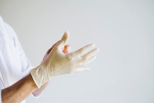 The doctor is on the front line. The doctor or nurse wears gloves. The doctor's hands are wearing medical gloves.