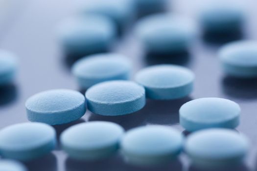 Tablets scattered blue color on the table of pharmaceutical laboratory pill for the prescription and treatment various diseases chemistry