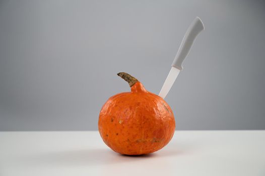 Knife in a pumpkin on a white background. Halloween symbol