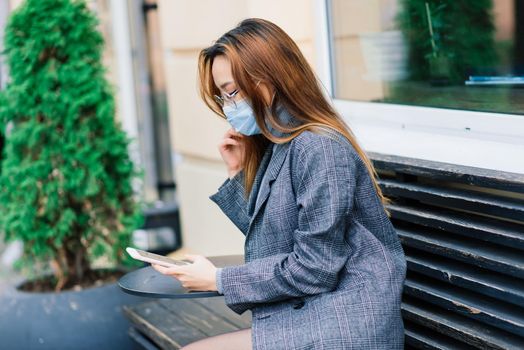 Young fsian woman wearing face mask is standing at a domestic street. Concept new normal of commuters after covid-19 epidemic