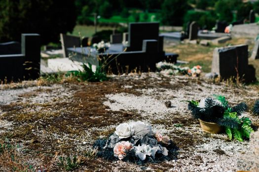 Rows of an old abandoned graves in a Catholic cemetery. The rickety gravestones.