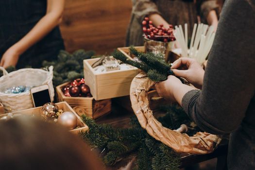 Woman making christmas wreath. A master class on creating a Christmas wreath from a natural spruce with your own hands. A Christmas wreath made with your own hands.