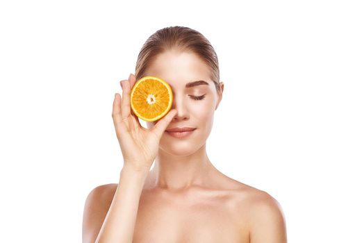 Beautiful womans face with orange close up studio photo on white background. Light hair, grey eyes, closed eyes