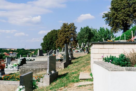 Rows of an old abandoned graves in a Catholic cemetery. The rickety gravestones.