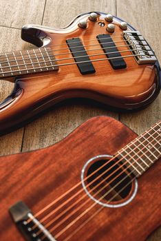 Choosing a guitar...Top view on two perfect polished musical instruments: acoustic and electric guitars are lying on the wooden floor in a music shop. Musical instruments. Music concept. Guitar body