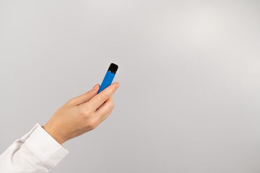 Faceless woman holding a disposable vape on a white background