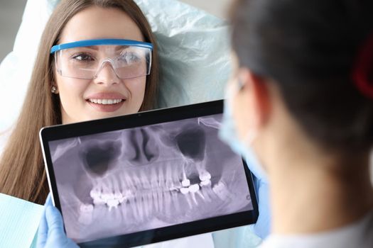 Female doctor orthodontist holds a snapshot of the jaw. Girl on examination at the dentist, dental prosthetics