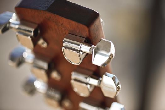 Guitar mechanism. Guitar headstock with focus on string winding mechanism: pegs, strings, vulture. Musical instruments. Music concept.