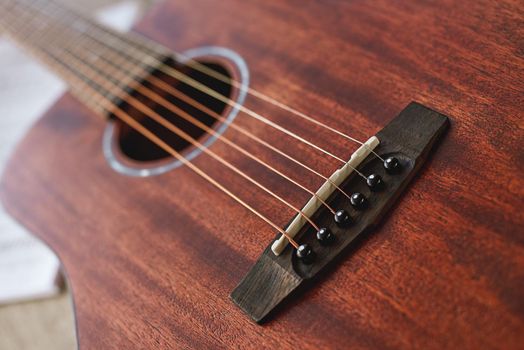 Favourite musical instrument. Close up view of beautiful brown guitar with six metal strings. Music equipment. Musical instruments. Music concept