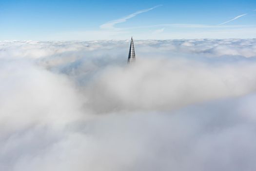 Russia, St. Petersburg, 14 October 2021: The top of the tallest skyscraper in Europe above the clouds, the building of the Gazprom oil company, the spire of a metal and glass structure. High quality photo