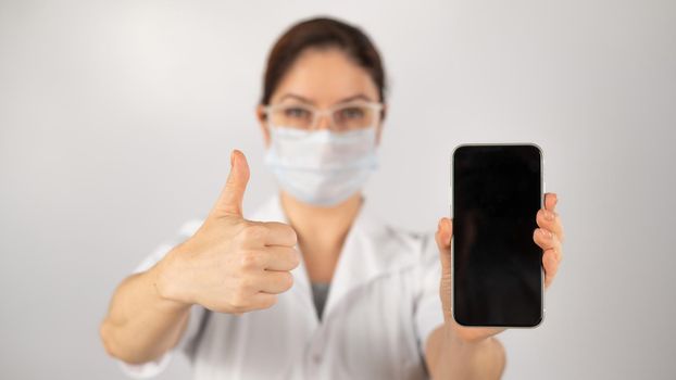 The doctor holds a smartphone with a black screen on a white background