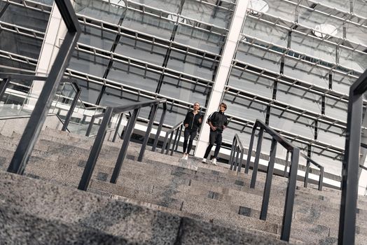 Early morning workout. Young couple running downstairs near the football stadium. Living healthy lifestyle.