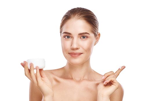 Beautiful womans face with facecream close up studio photo on white background. Light hair, grey eyes