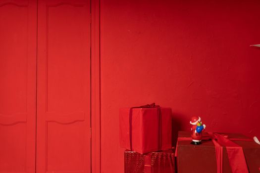 Big wrapped gifts near red wall. Boxes of presents on red background. Concept of holidays and surprises