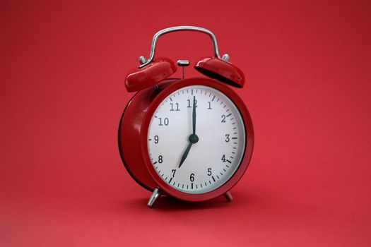 Vintage stylish alarm clock with bells on a red background, close-up. Planning and deadline. Productivity of the day