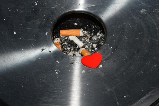 Heart on a ashtray with cigarette butts