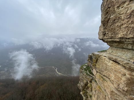 Beautiful landscape of huge cliff with spectacular view of nature. Close up of high rock in foggy and cloudy weather