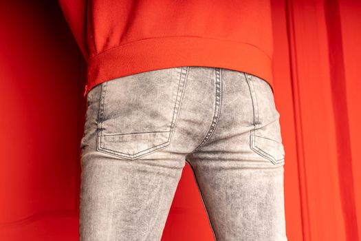 Close up of male buttocks in grey jeans. Rear view on buttocks of unrecognizable man