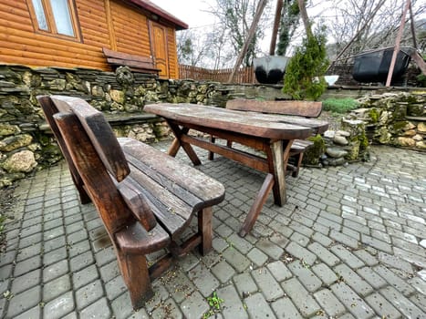 Close up of wooden table with benches in countryside. Log table and benches in empty village in cloudy weather