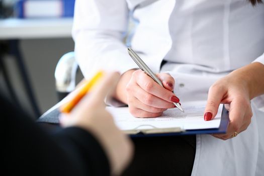 Female medicine doctor hand hold jar of pills and write prescription to patient at worktable. Panacea and life save, prescribing treatment, legal drug store concept. Empty form ready to be used