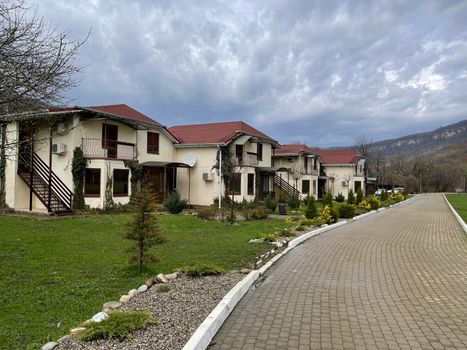 Close up of residential buildings in mountainous terrain. Cottage houses in countryside in cloudy weather