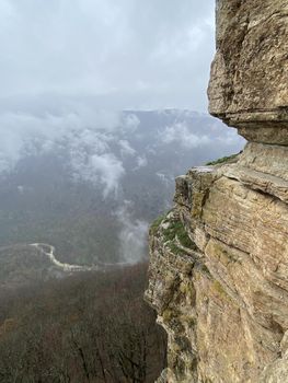 Beautiful landscape of huge cliff with spectacular view of nature. Close up of high rock in foggy and cloudy weather