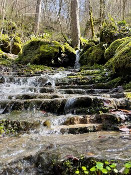 Beautiful landscape of mountain stream flowing down stone steps. Mountain waterway flowing down natural stairs in picturesque place